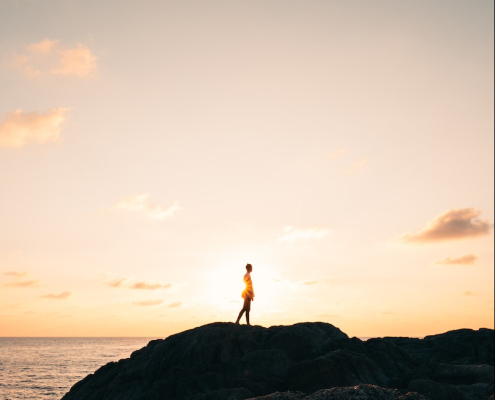 Person Standing on Rock Mountain Fronting the Sea