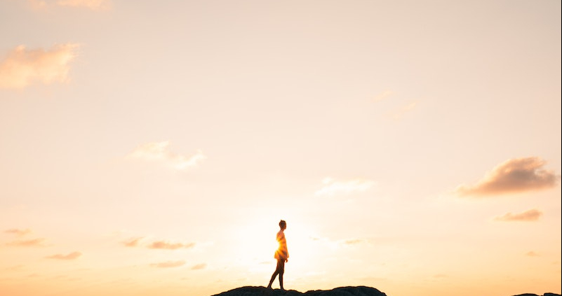 Person Standing on Rock Mountain Fronting the Sea