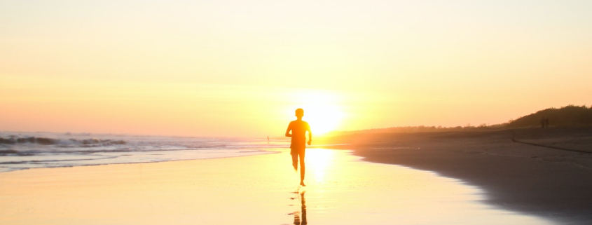 Silhouette of Boy Running in Body of Water during Sunset