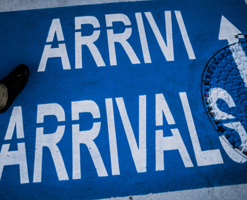 person standing on arrivals sign